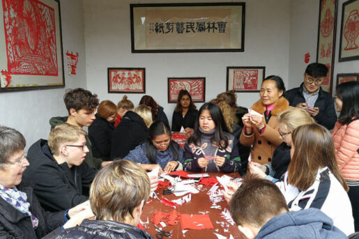 Overseas volunteers doing traditional Chinese papercuts in a village in China