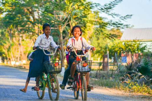 Cambodian students riding to their school which is supported by Amity