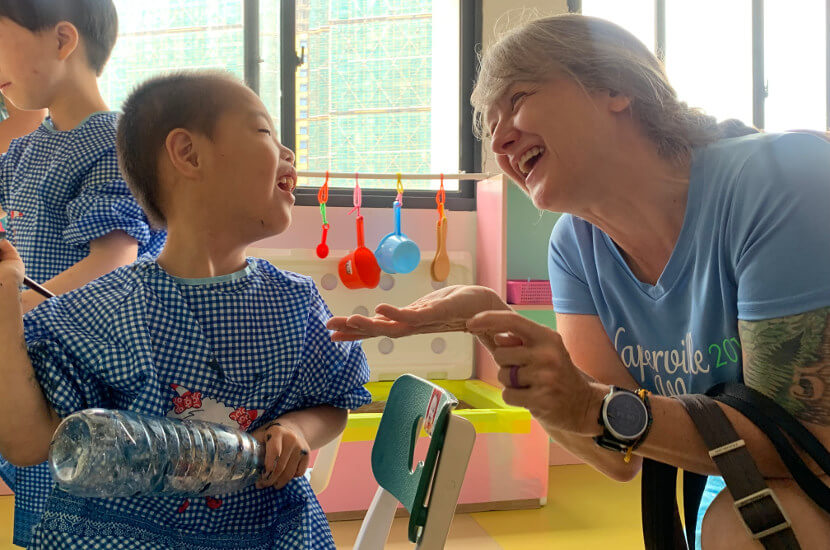 An overseas care expert playing with a kid at the Amity children development center