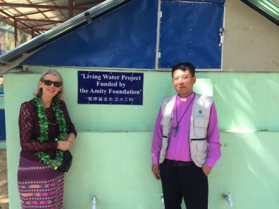 Debbie and the Bishop of Diocese of Toungoo standing in front of the new sanitation facilities built by Amity's water program