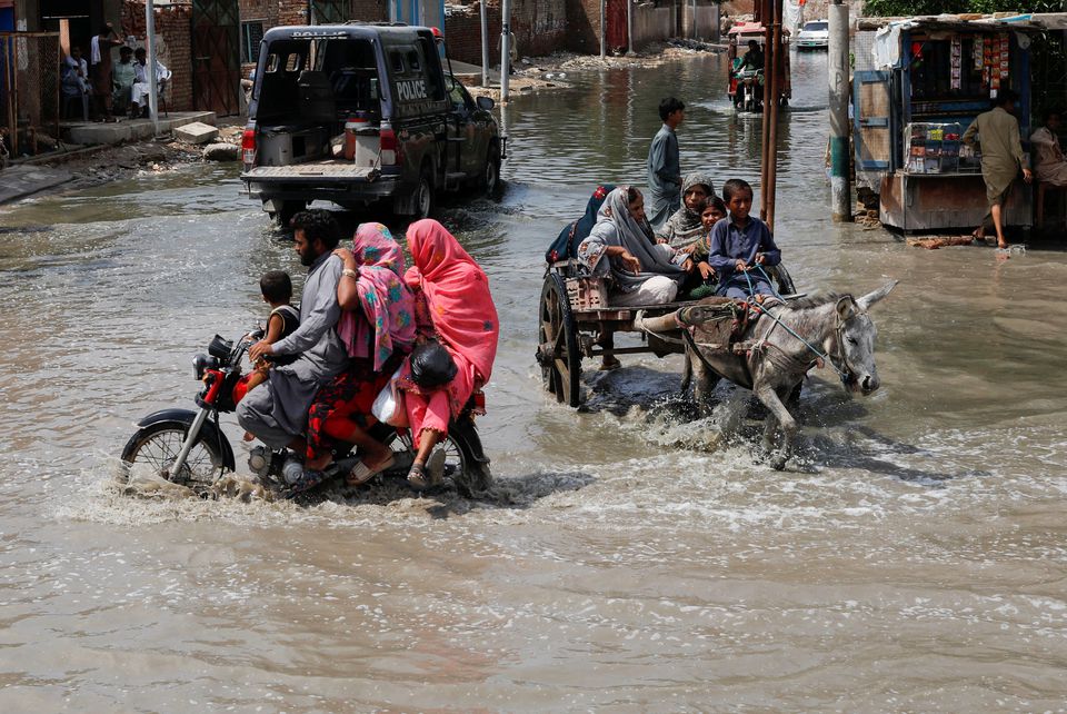 Commuters travel through rain waters following rains and floods during the monsoon season in Jacobabad Pakistan August 30 2022. REUTERS Akhtar Soomro